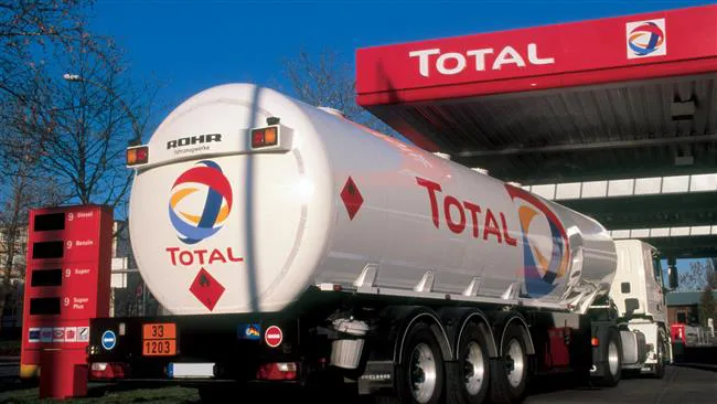 Total-branded fuel tanker truck refueling at a Total service station