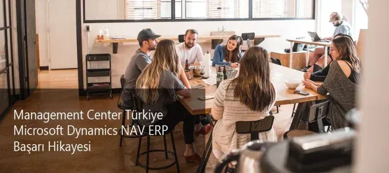 Group of professionals gathered around a table with laptops in a casual meeting