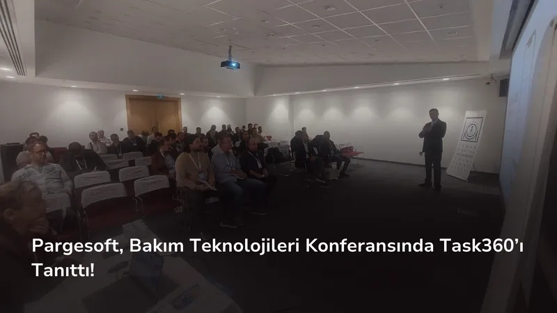 Konferans salonunda oturan katılımcılar ve önde ayakta sunum yapan bir konuşmacı