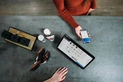 Bir masa üzerinde tablet ve akıllı telefonla ERP tabanlı konuk ağırlama yazılımının kullanımı