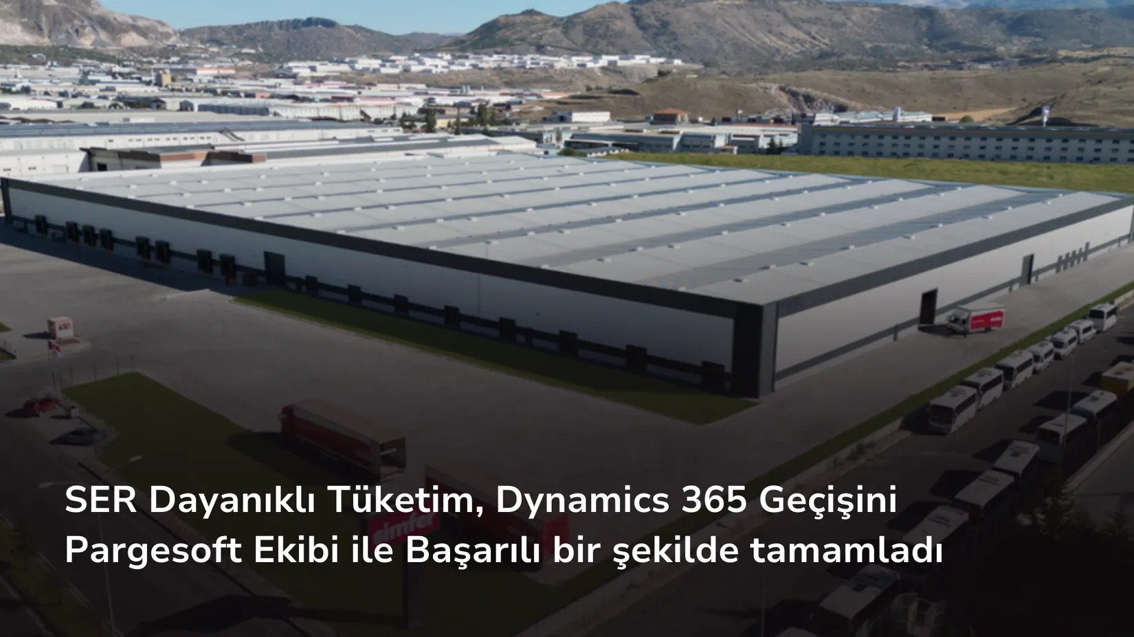 Havadan çekilmiş görüntüde büyük bir depo binası, önünde kamyonlar ve Simfer tabelası görünüyor