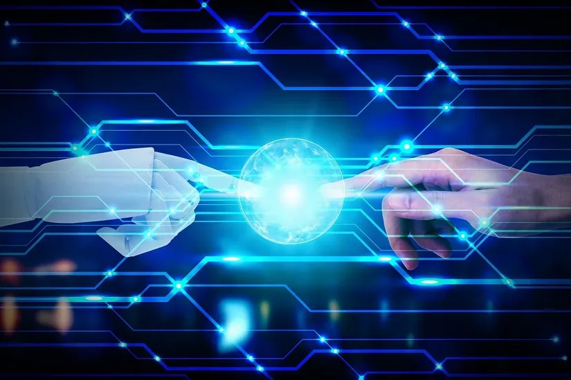 Bir robot eliyle insan elinin parmak uçlarının parlayan bir küreye dokunması