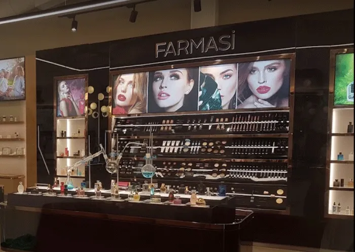Farmasi store display with makeup products arranged on shelves and model posters