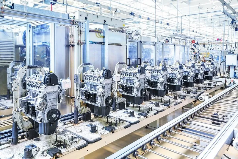 Fabrika üretim hattında konveyör üzerinde sıralanmış otomobil motorları