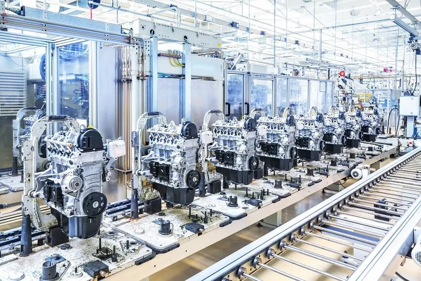 Fabrika üretim hattında konveyör üzerinde sıralanmış otomobil motorları