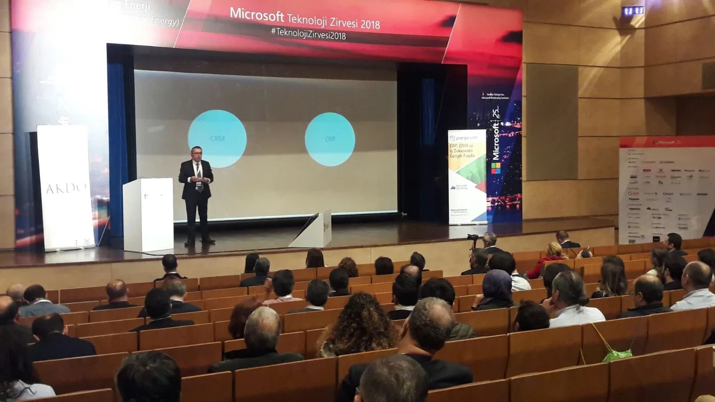 Microsoft Teknoloji Zirvesi 2018 sahnesinde CRM ve ERP başlıklı iki daireli slaytı sunan konuşmacı