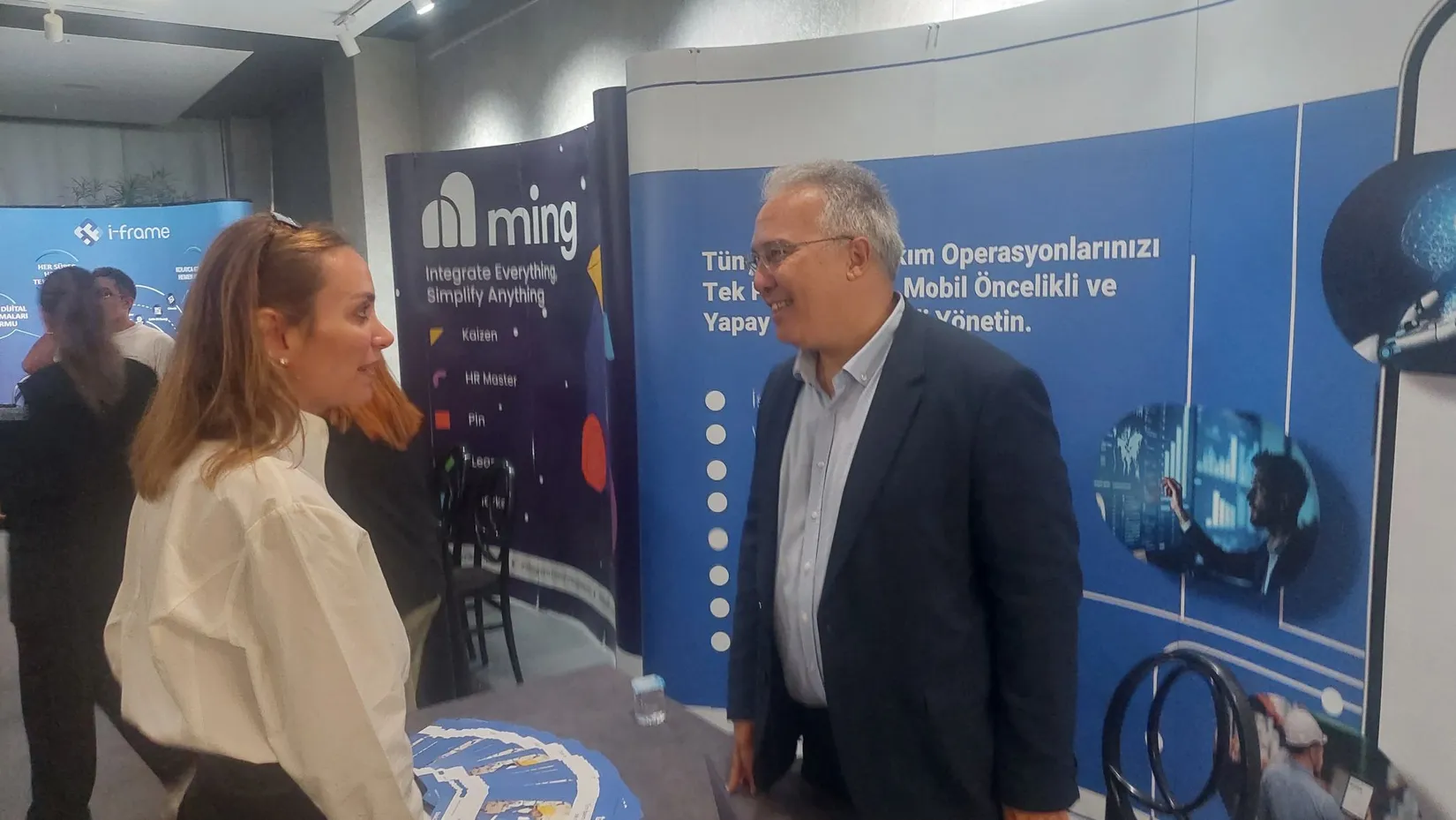 Ming ve i-frame stantları önünde birebir sohbet eden iki katılımcının yakın çekimi