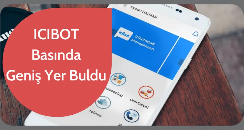 Ahşap masada duran telefonda ICIBOT4Staff Management uygulaması: housekeeping ve oda servisi simgeleri