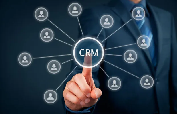 Takım elbiseli bir kişinin, çevresinde bağlı kişi ikonları olan 'CRM' simgesine dokunduğu kavramsal görsel